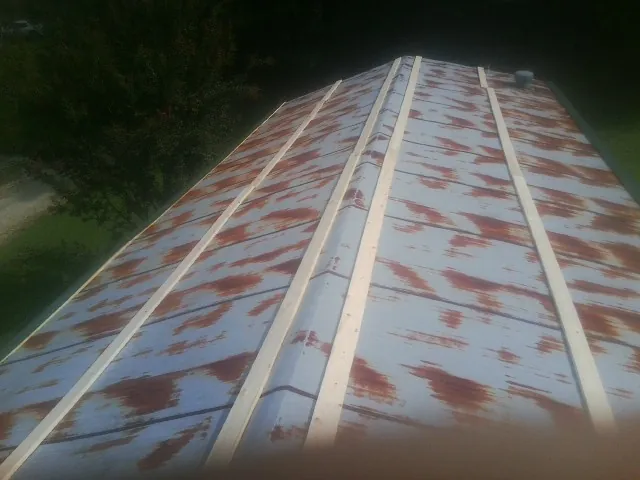 Rusted metal roof panels with new wood purlins before replacement — Storm Damage Roof Repair in Walkerton by Roofing Brothers