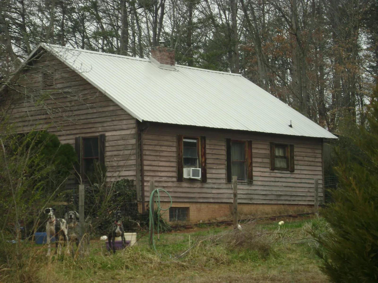 White metal roof on an old wood sided farmhouse, from a Metal Roof Installation job in Walkerton